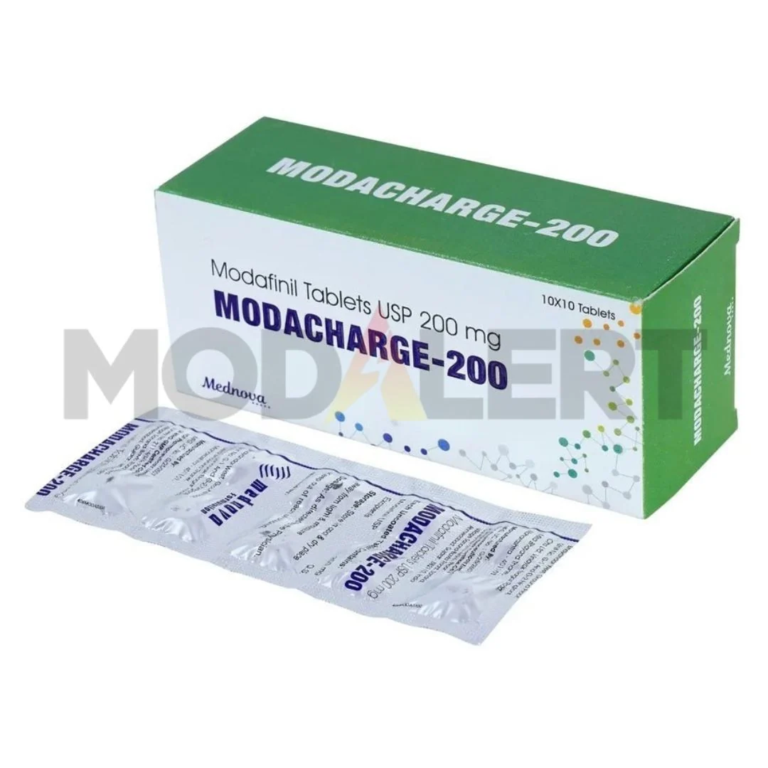 Buy Modacharge 200 mg Online green-and-white Modacharge 200mg carton displaying modafinil labelling alongside a silver blister strip.